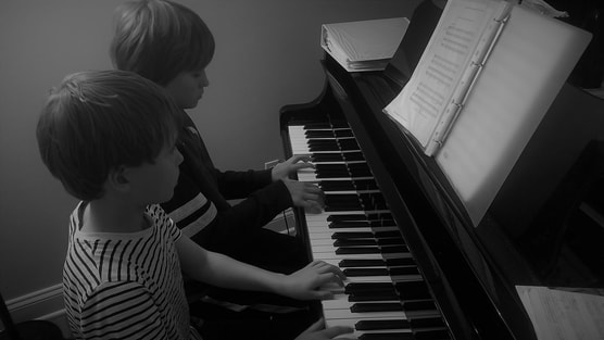 Two students learning to play piano